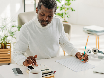 Homme assis à un bureau calculant les frais