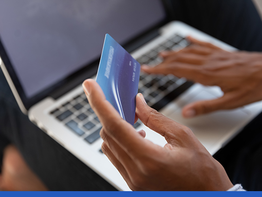 Close up of woman entering credit card information on laptop