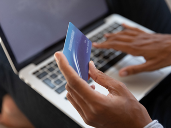 Close up of woman entering credit card information on laptop